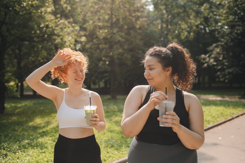 friends on a walk enjoying a beverage in the park